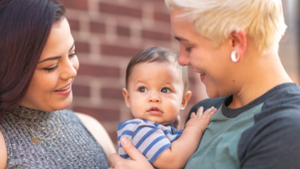 Photo of two women holding a baby