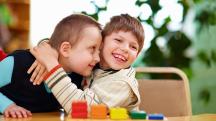 Photo of two boys smiling and hugging