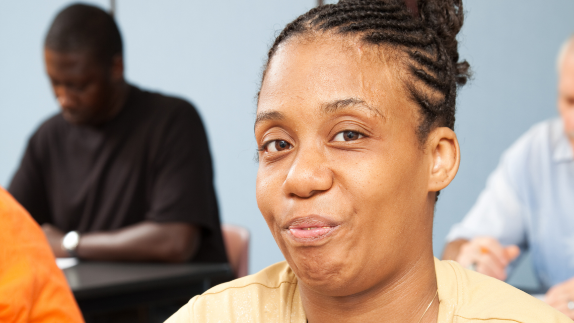 Photo of a woman in close up with students in the background