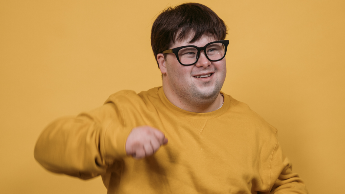 Photo of a young man in a yellow jumper